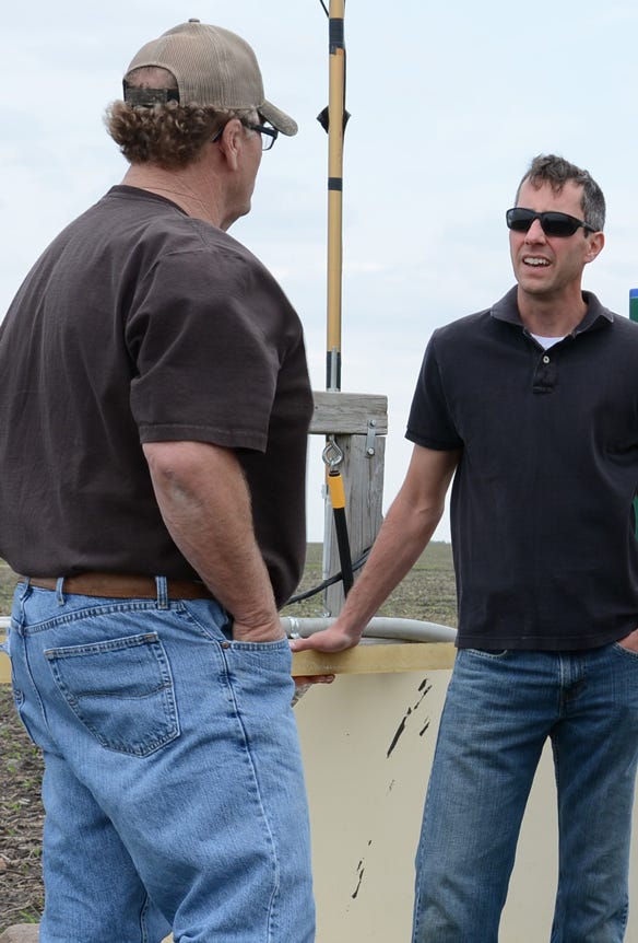 Kevin Kuehner, a hydrologist with MDA, talks with another man