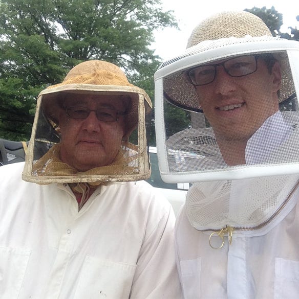 Mark Noll and son Ethan wearing beekeeper gear