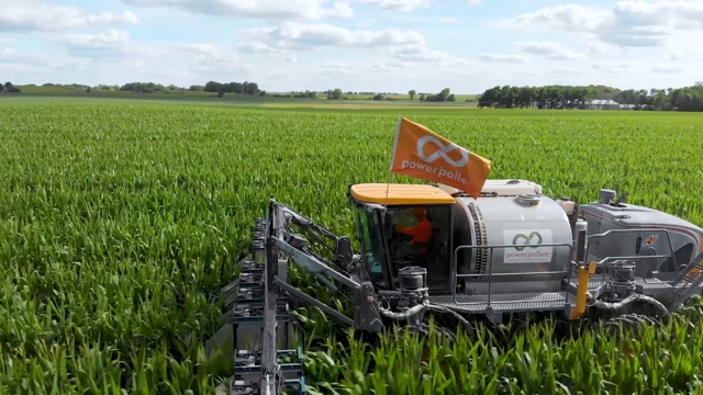 PowerPollen implement driving through a field of corn.