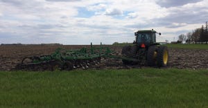 John Deere tractor pulling digger in field.jpg