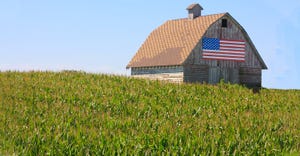 U.S. flag on barn in green field