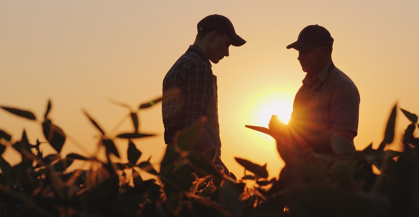 2 farmers talk in a field. 2 farmers talk in a field.
