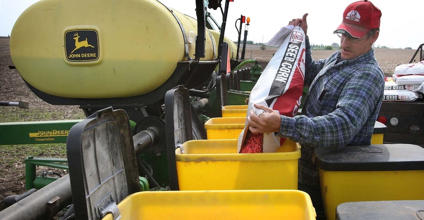 Farmer filling corn planter with seed corn