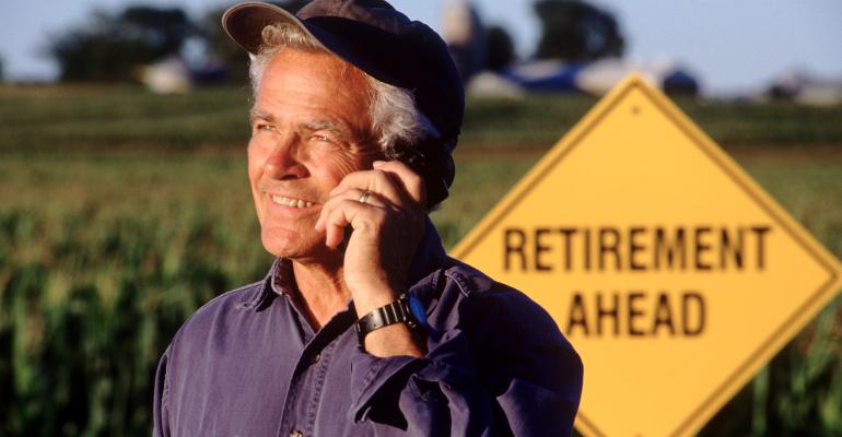 Older farmer talking on cell phone, planning retirement