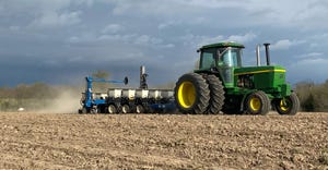 John Deere tractor pulling planter across field