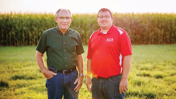 Father and sun posed in front of corn field