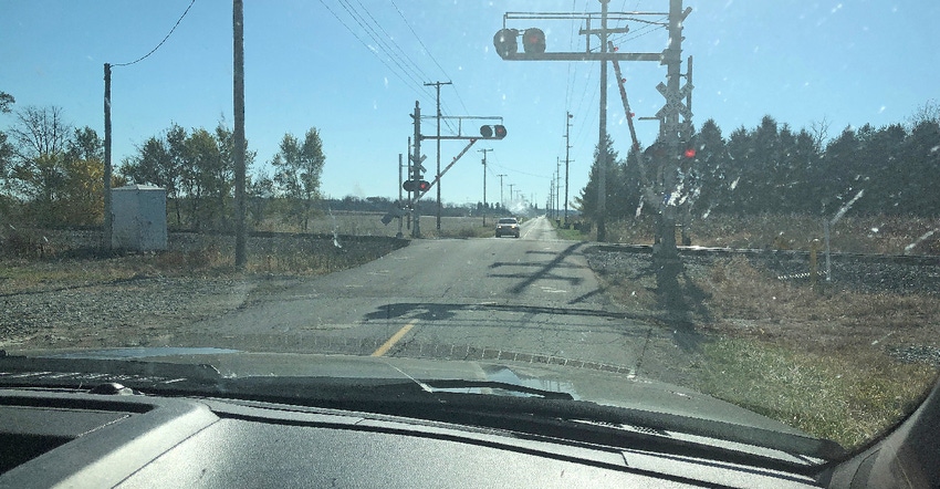car sitting by railroad crossing