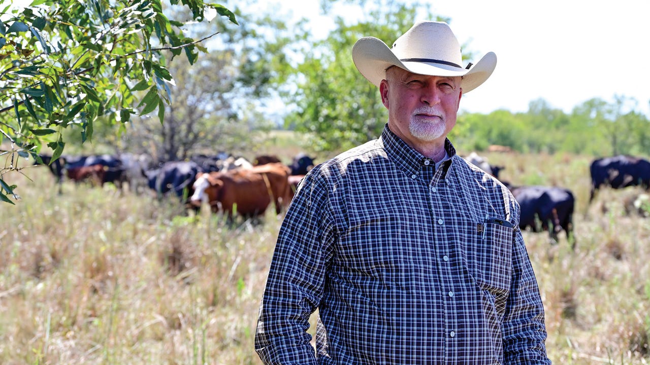 Ranger Hugh Aljoe posed in pasture with cattle