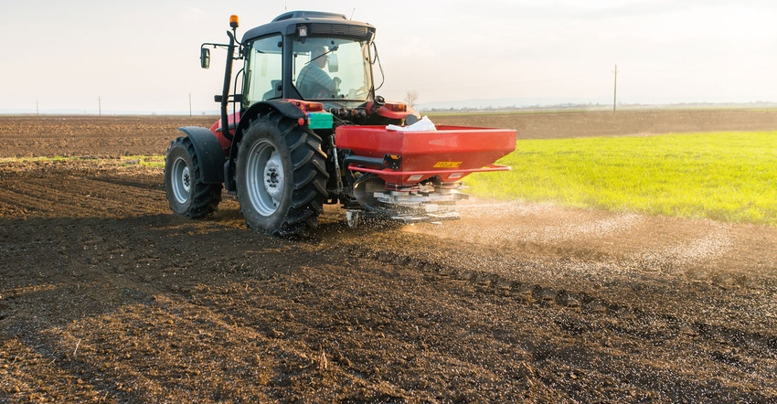 Tractor spreading fertilizer on a field