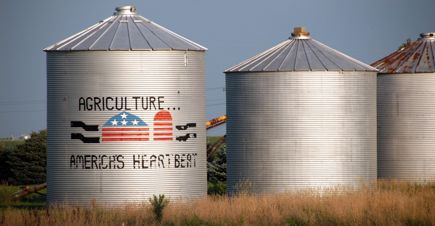 weathered grain bins with Agriculture...America's Heartbeat painted on the side