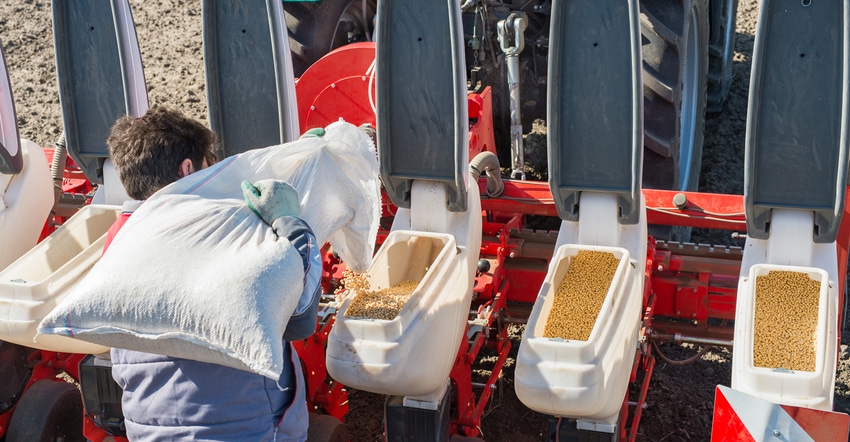 farmer loading soybean seeds into planter