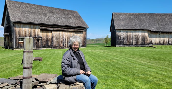 Connie Kheel sitting in front of an early 19th century German barn