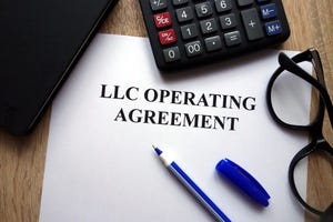 LLC Operating Agreement document on a desk with calculator and pen.