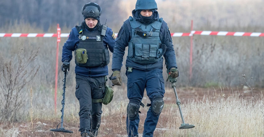 Men in gear detecting mines in fields in Ukraine