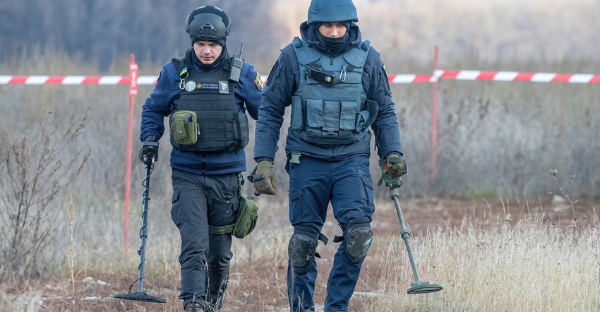 Men in gear detecting mines in fields in Ukraine Men in gear detecting mines in fields in Ukraine