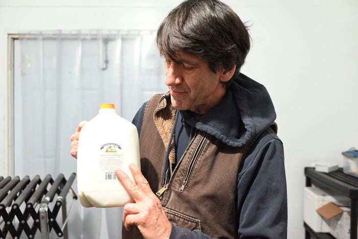 Mark Lopez holds a gallon of raw milk
