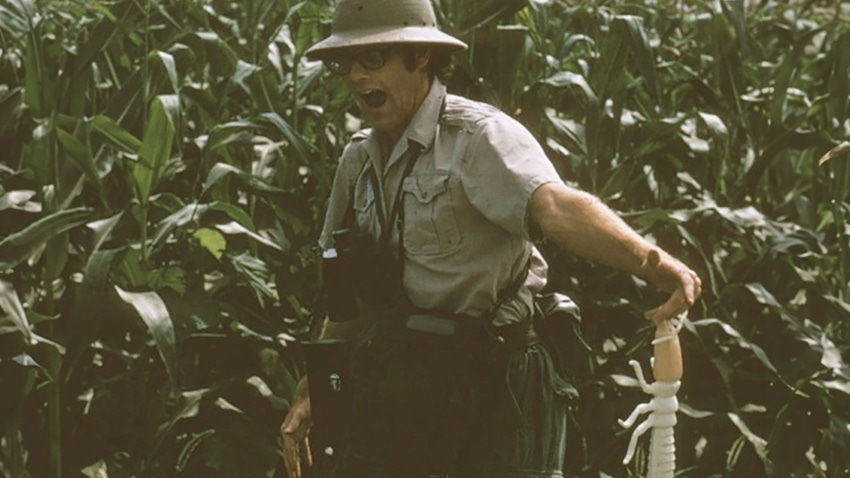  1970s photo of John Mumford dressed like an entomologist in a cornfield