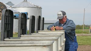 Farmer wearing a Kruger hat looking into a planter box