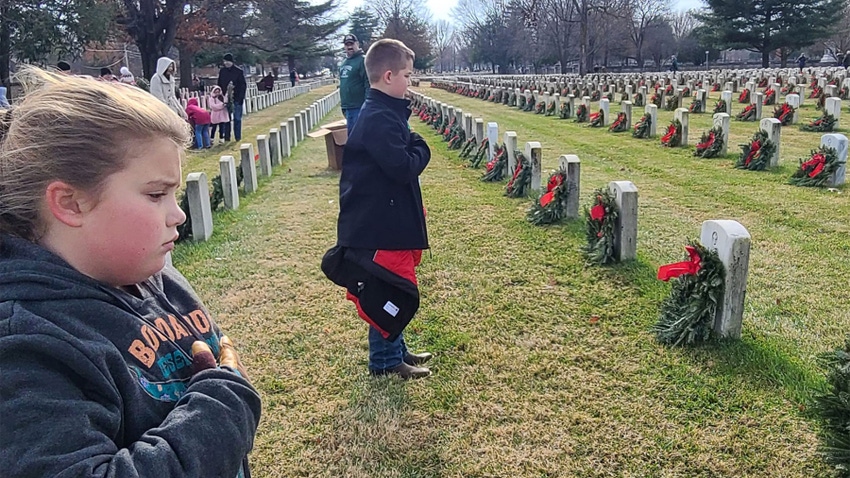 Aria Duwe, 9, left, and brother Payton Duwe, 12 at a wreath-laying ceremony at a cemetery