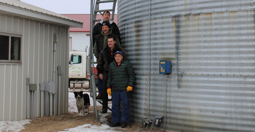 Les, Doug, Jon and their father, Wayne, Danielson posed on grain bin steps with dog, Mia 