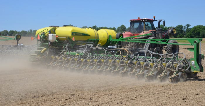 John Deere planter and red tractor planting corn