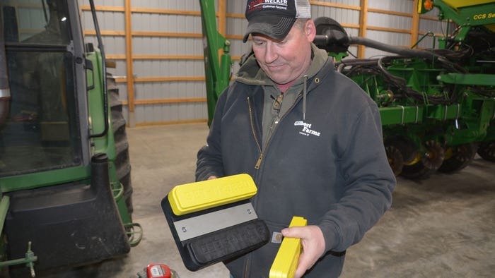Pete Illingworth of the Purdue Throckmorton Ag Center holds key pieces of the Set-N-Seed kit