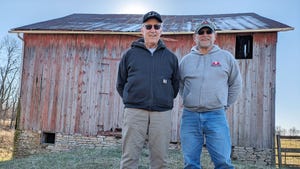 Darrell Boone and Randy Miles standing in front of a barn and smiling