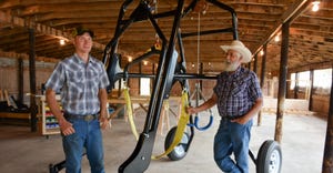 E.J. Swihart and his cousin Roger Swihart stand beside their Cow Crane