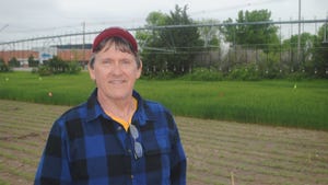 UNL plant pathologist, Bob Harveson standing near a field trial plot of chickpeas
