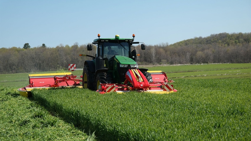 A tractor plowing through forage