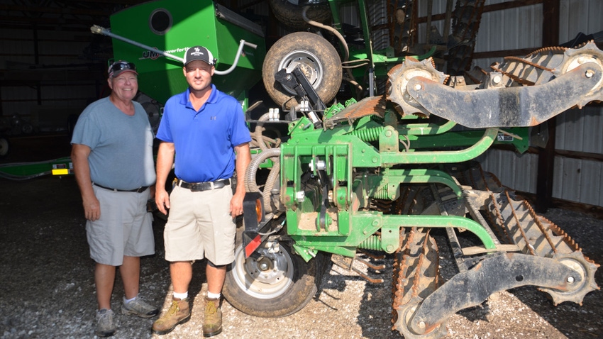 Steve Schwering (left) and his sons Adam (right) and Curtis pull this rolling harrow across fields while seeding cover crops with the on-board air seeder