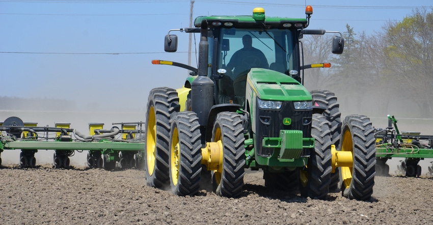 John Deere tractor pulling planter in field