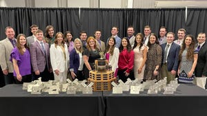 Members of K-State National Champion Meat Animal Evaluation Team behind table holding awards