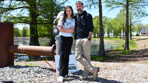 Teen daughter and father standing in front of an irrigation pump.