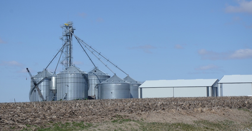 Silos, barns and corn field.