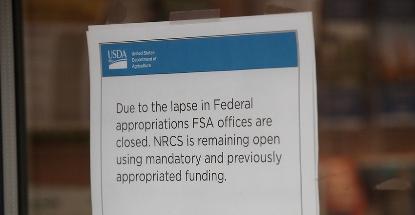 A paper sign reading 'Due to the lapse in Federal appropriations FSA offices are closed' is taped to a glass office door