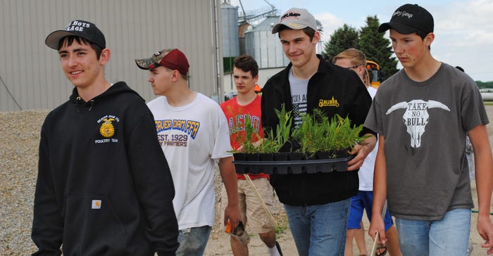 students carry plants and tools 