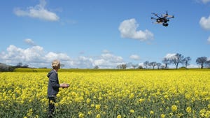 man flying drone over rapeseed field