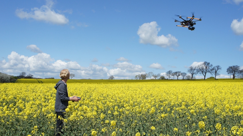 man flying drone over rapeseed field man flying drone over rapeseed field