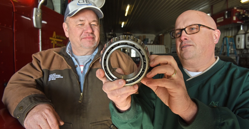 two men looking at a large bearing two men looking at a large bearing