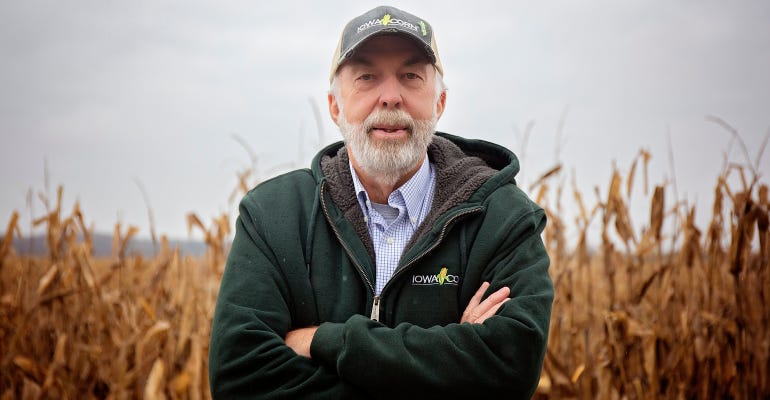 Larry Buss standing infront of corn field