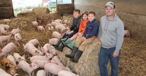 Josh Humphreys with his children and feed pigs