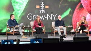 Panelists sit on a stage as a moderator facilitates a debate at the Grow-NY Summit