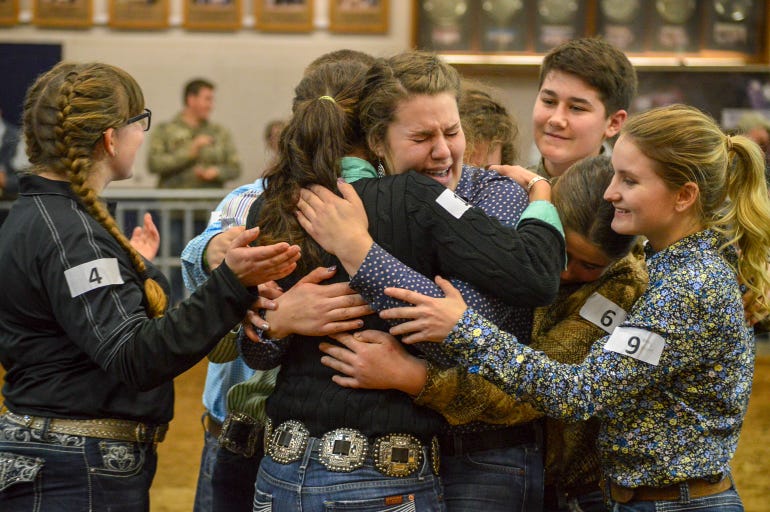 Competitors in the Master Showman competition at the Pennsylvania Farm Show embrace Heidi Barkley