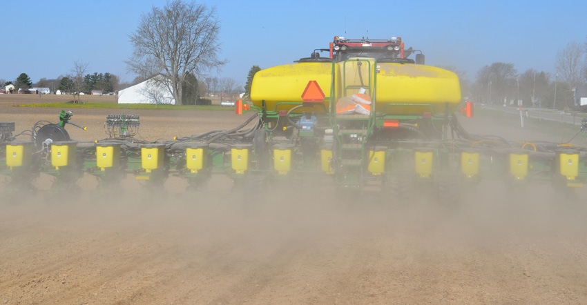 planter kicking up dust in field
