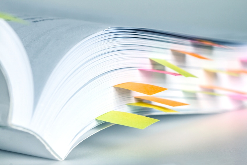 Textbook with colorful sticky notes marking pages.