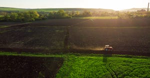 Aerial view of tractors working on the harvest field.