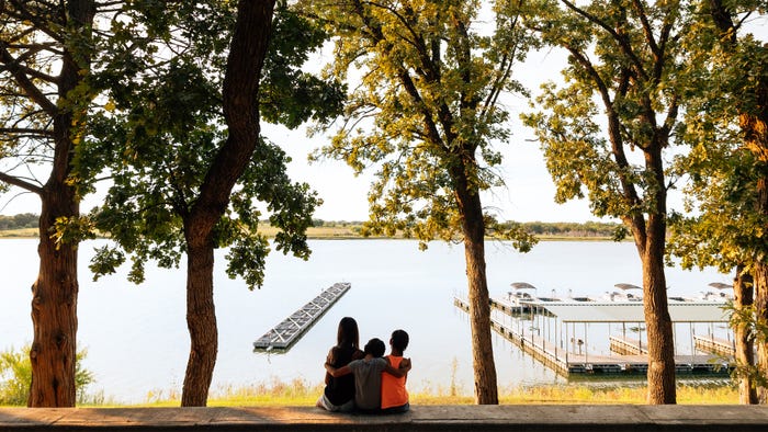 people sitting on shore of lake, looking out