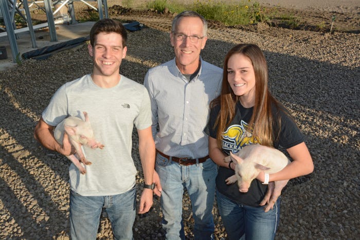 Karl Schenk and his children, Karl II and Kyra, holding piglets