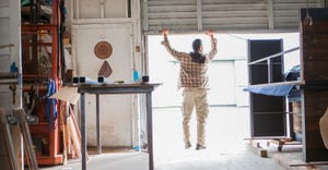 man lifting metal door of workshop